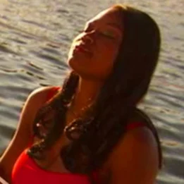 赤いシャツと赤いシャツを着た人で、後ろに水域があります