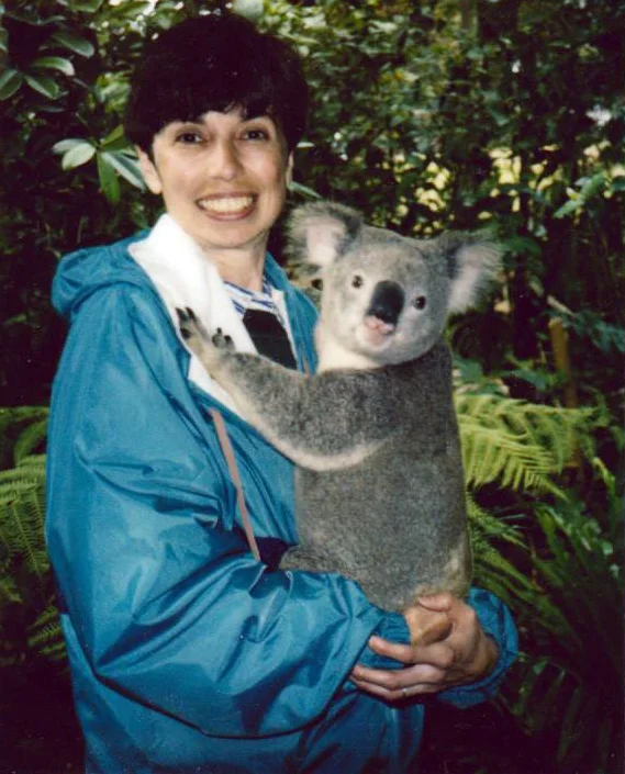 woman living with an ostomy holding a koala bear during her travels in Australia 