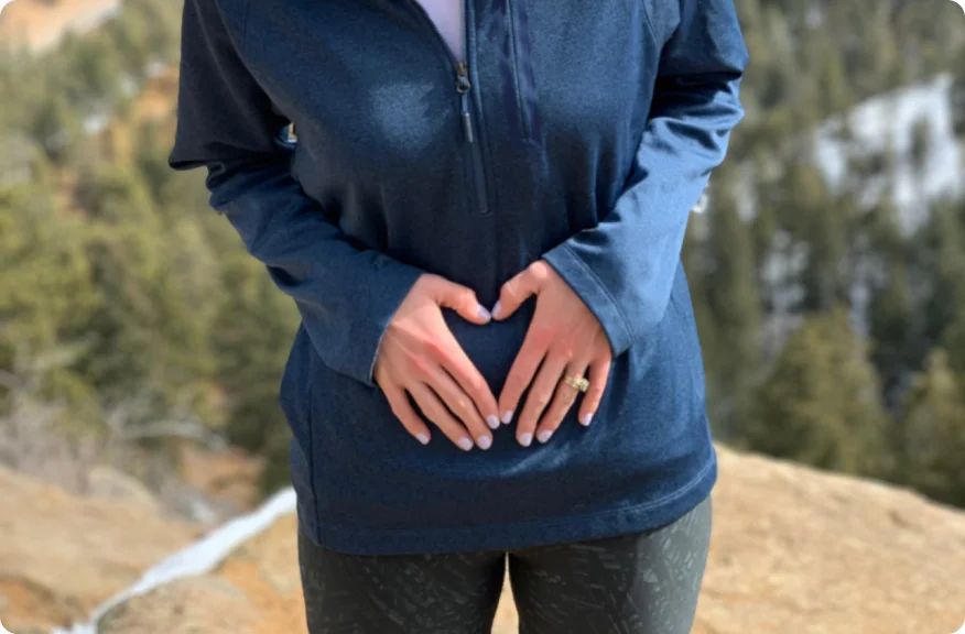 女人双手放在肚子上站立，代表造口手术后有意义和充实的亲密接触的可能性。