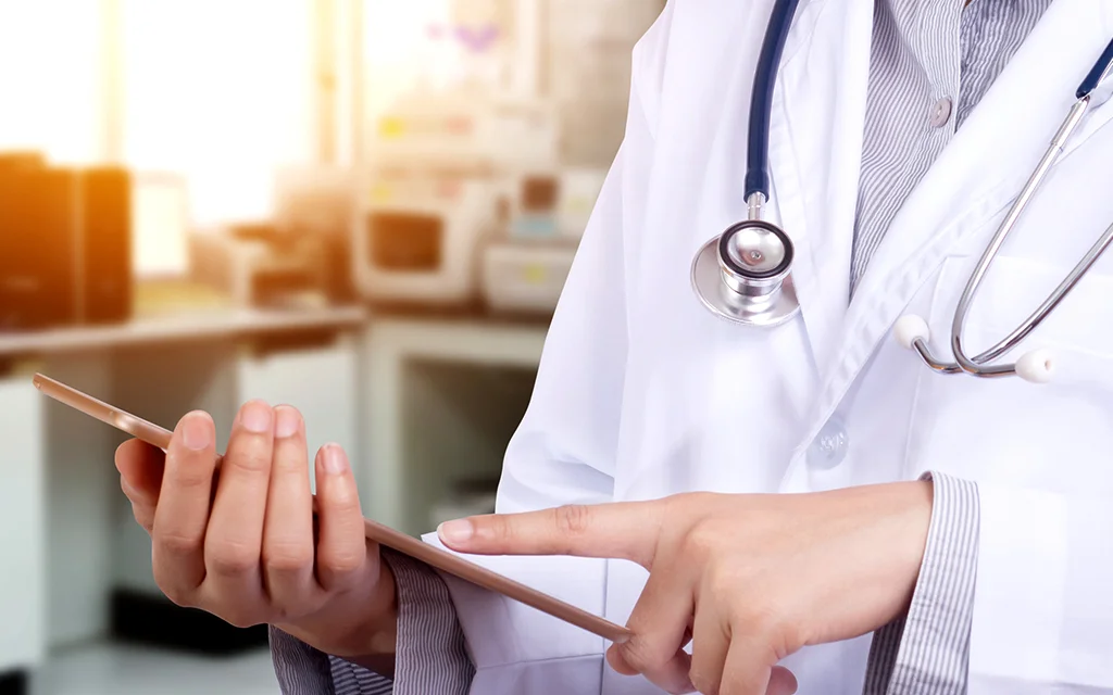 lekár držiaci pacienta za ruku